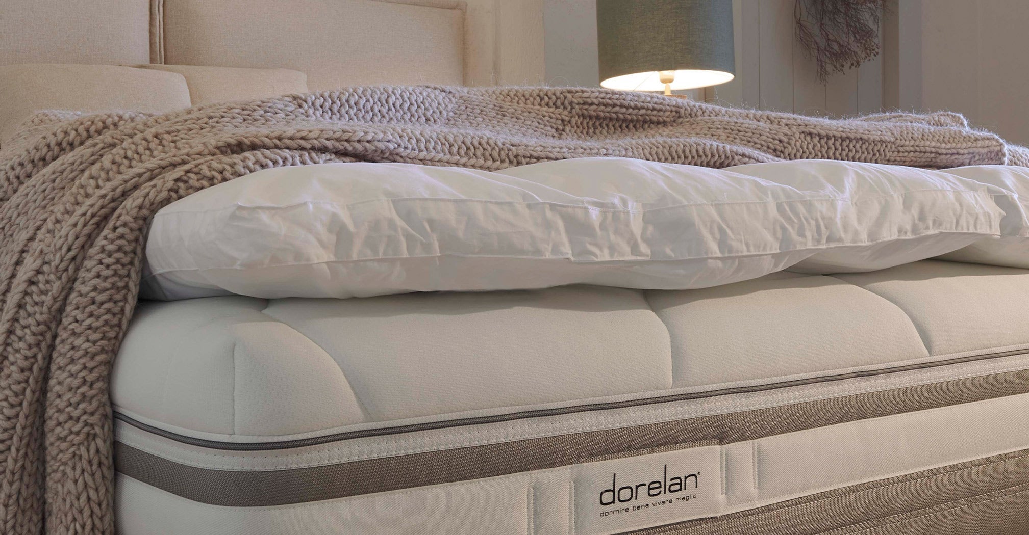 A cozy bed showcasing a comfortable mattress topped with soft pillows, representing authentic Italian craftsmanship.