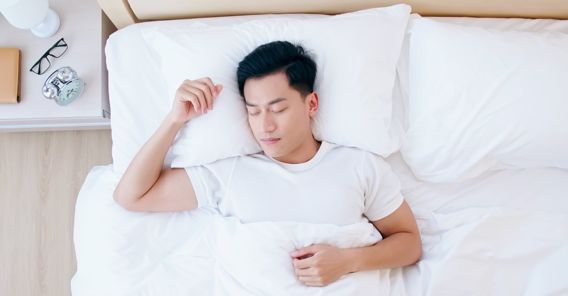 view from above man lying on bed with head on pillow 